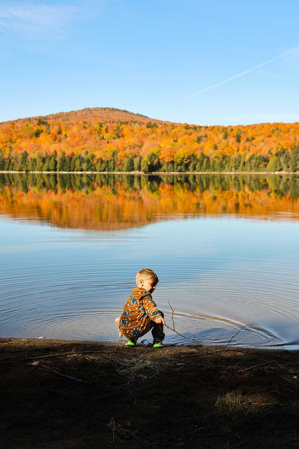Child standing at edge of pond