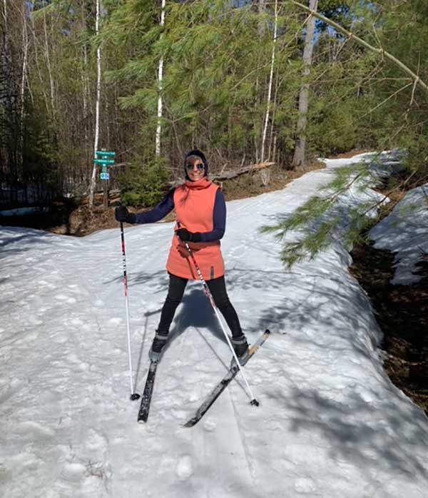 woman posing on skis on snow-covered trail 