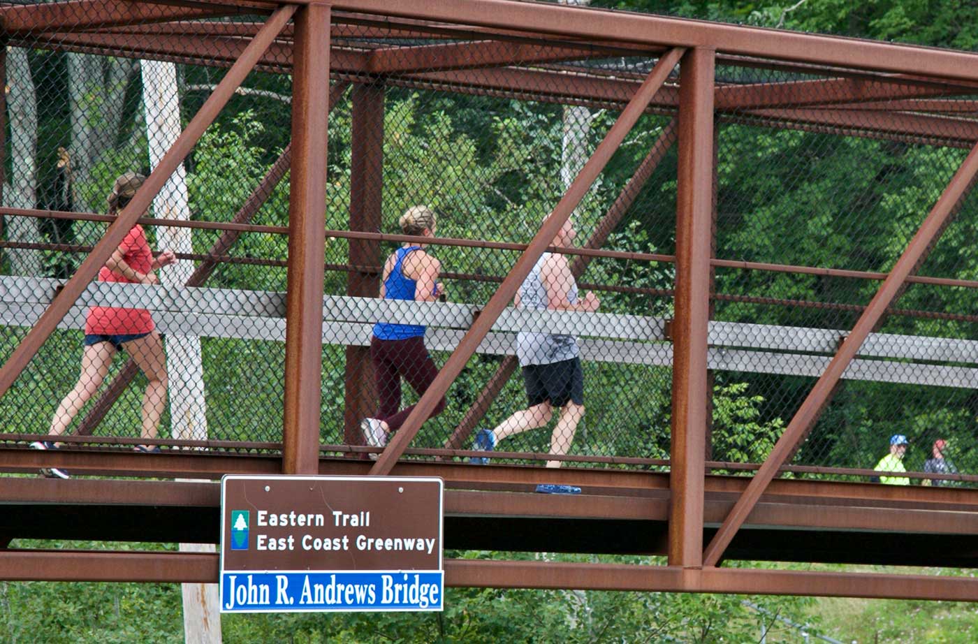 people running across bridge