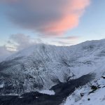 Katahdin peak in winter snow with pink cloud overhead