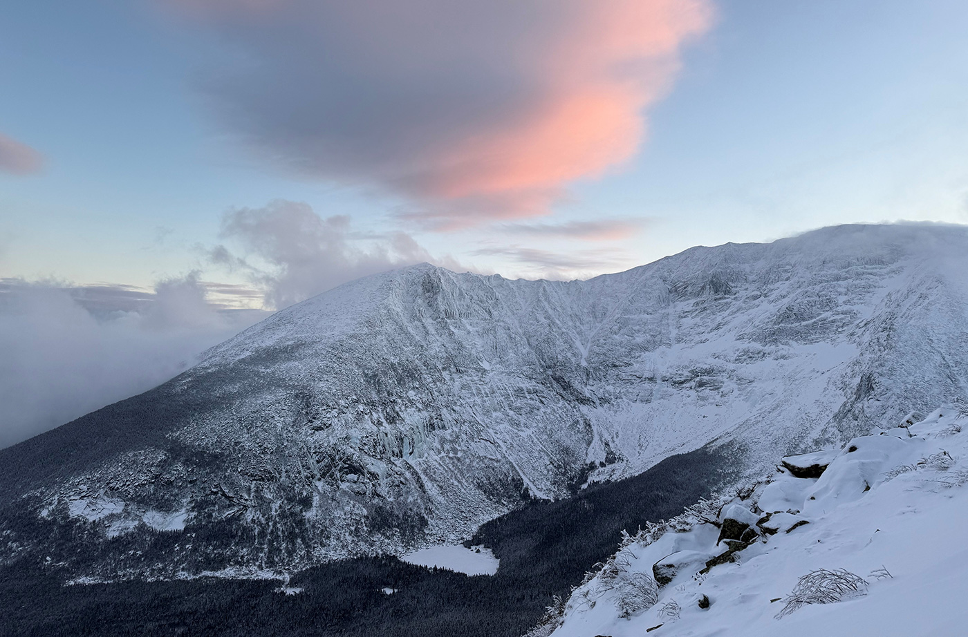 Katahdin peak in winter snow with pink cloud overhead