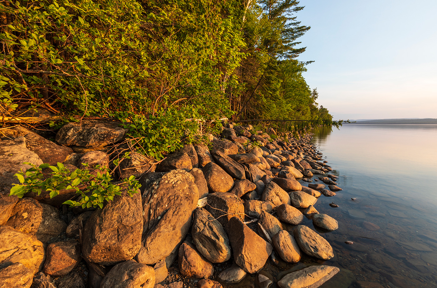 rocks and trees along shoreline of lake