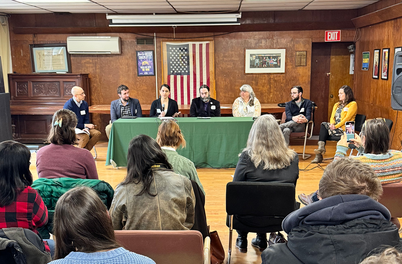 People sitting at a table having a discussion in front of an audience